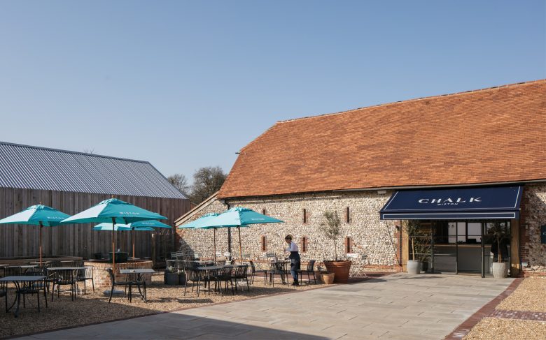 Courtyard with dining space in front of flint barn